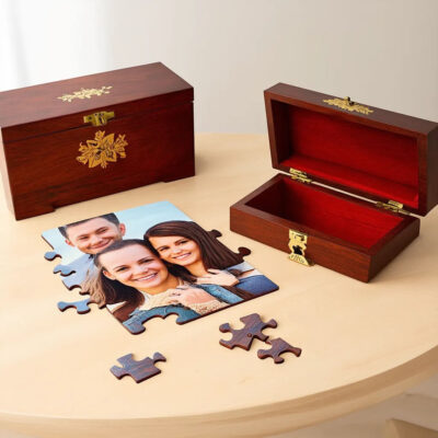 A partially assembled custom wooden puzzle of a family photo next to an elegant wooden box casket on a light-colored table.