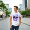 A young man wearing a white T-shirt featuring a bold purple skull design while standing in a modern cityscape.