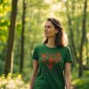 Woman in a green T-shirt with a red paw print heart design and the phrase “My Heart Belongs to a Four Legger,” walking in a sunlit forest.