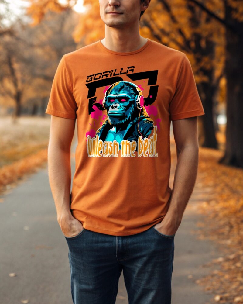 Man wearing orange T-shirt with gorilla DJ print and "Unleash the Beat" slogan in an autumn park.