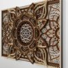 Close-up angled view of a multilayer wooden mandala wall art piece in natural wood tones, showing intricate carved details and layered depth against a light wall.