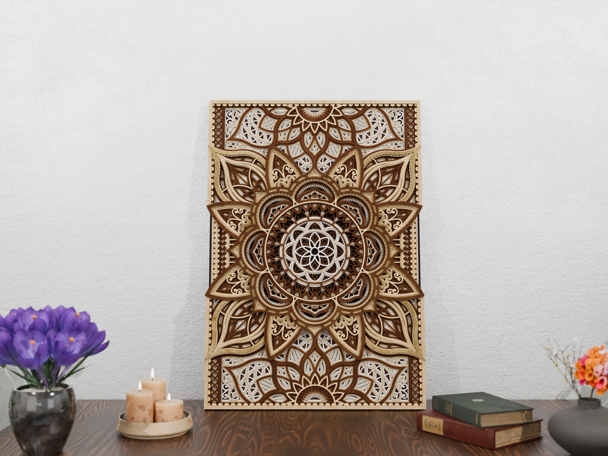 Vertical multilayer wooden mandala wall art in natural wood tones displayed on a wooden table against a light textured wall, with candles, books, and flower vases nearby.