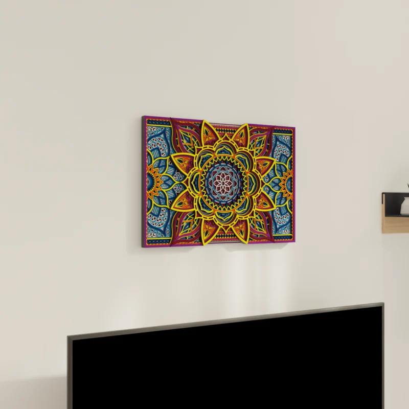 Multilayer Wooden Mandala wall art with a bright symmetrical floral geometric design in yellow, blue, red, and purple, shown on a light wall above a TV from an angled view.