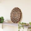 Multilayer Wooden Mandala wall decor in natural wood tones displayed on a wall above a shelf in a styled interior