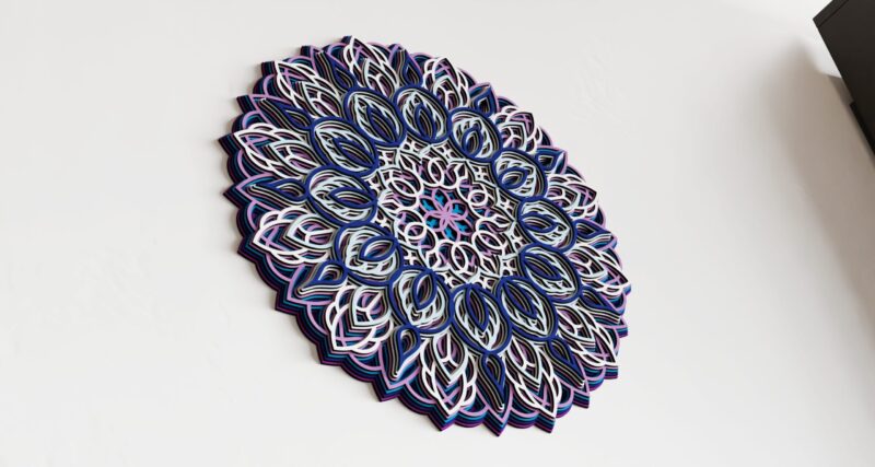 Close-up of a Multilayer Wooden Mandala in blue, white, and pink with a symmetrical layered design