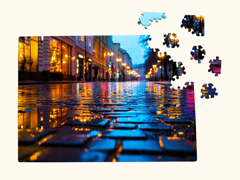 Partially assembled wooden jigsaw puzzle showing a rainy city street with glowing lights and colorful reflections.