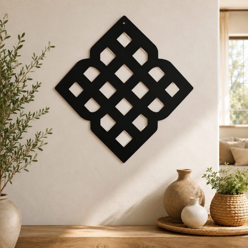 Black geometric Celtic knot wall decor displayed on a neutral wall in a warm modern interior with plants and ceramic vases.