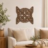 Dark wood Celtic knot wall decor displayed above a neutral sofa in a warm modern living room.