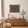 Natural wood multilayer mandala wall art displayed above a wooden console in a warm neutral living room.