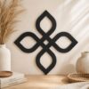 Close-up of black Celtic Knot wall decor displayed on a light wall with neutral home accessories.