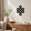 Black Celtic Knot wall decor displayed above a wooden sideboard in a warm neutral living room.