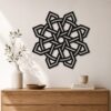 Large black Celtic Knot wall decor displayed above a wooden console in a minimalist interior with natural decorative accents.