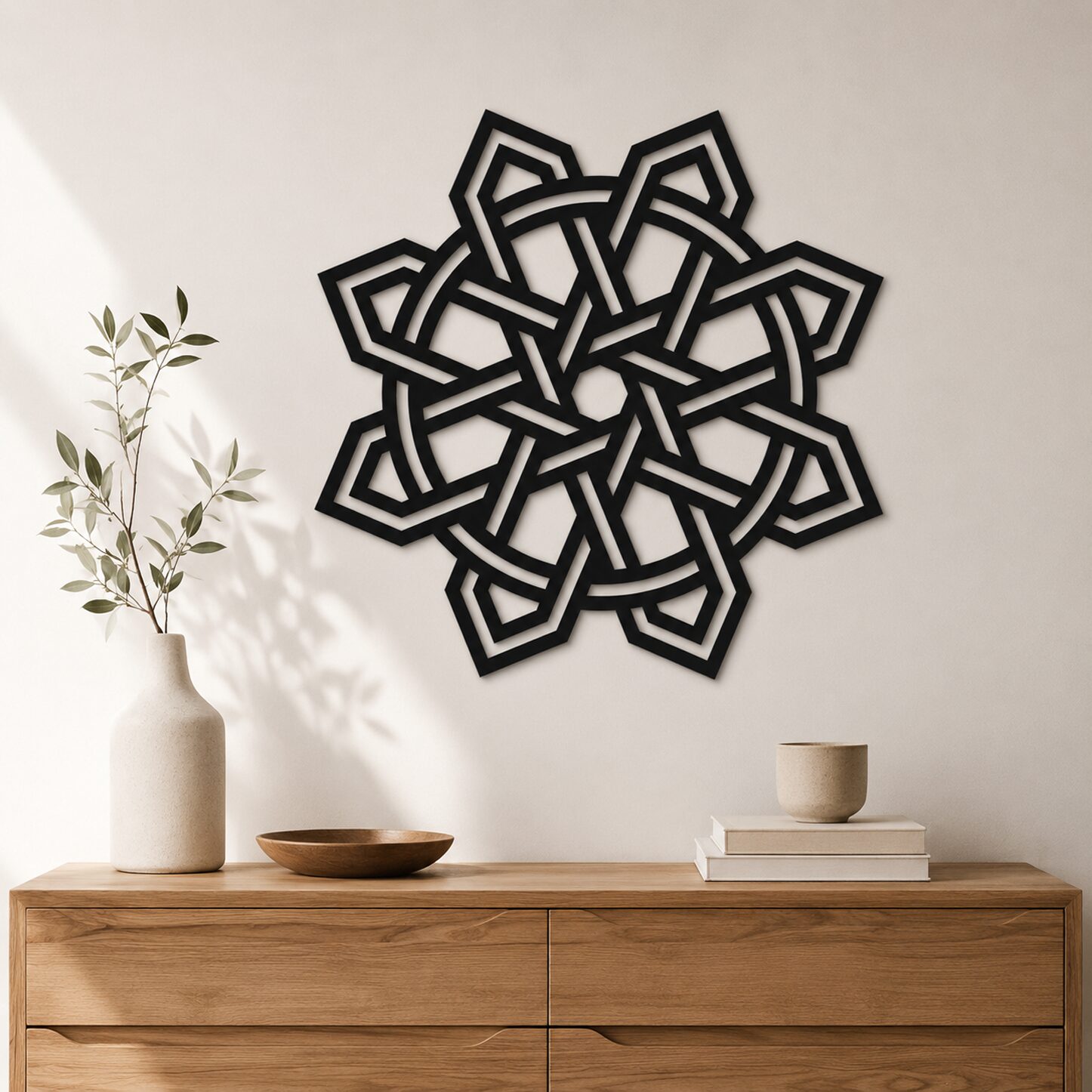 Large black Celtic Knot wall decor displayed above a wooden console in a minimalist interior with natural decorative accents.